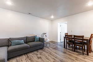 Living room with light wood-type flooring and recessed lighting