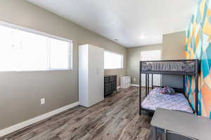 Bedroom with wood finished floors and baseboards