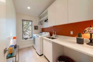 Laundry area featuring washer and dryer, recessed lighting, and cabinet space