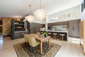 Dining area with a high ceiling, light wood-type flooring, recessed lighting, and beverage cooler