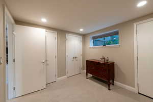 Bedroom featuring two closets, recessed lighting, and light carpet