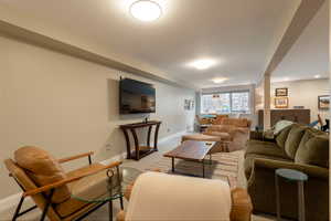 Carpeted living room with baseboards and recessed lighting
