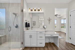 Full bathroom with vanity, a shower stall, and dark wood-style floors