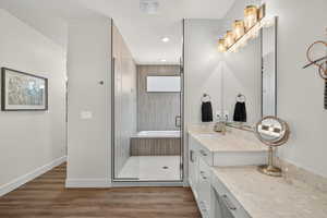 Full bathroom with light wood finished floors, a shower stall, vanity, and recessed lighting