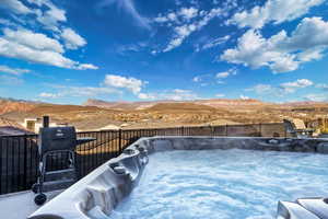 View of swimming pool featuring a mountain view and a hot tub