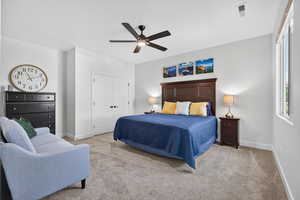 Bedroom with light colored carpet, ceiling fan, and a closet