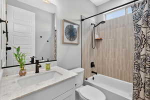 Bathroom with vanity and shower / bath combination with curtain