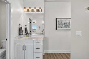 Bathroom with vanity, light wood-type flooring, and ceiling fan