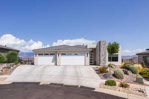 View of front of house with stucco siding, an attached garage, driveway, and a tiled roof