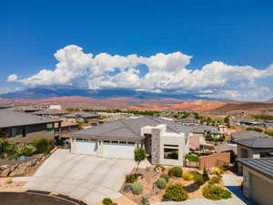 Prairie-style home with a residential view, an attached garage, stucco siding, a mountain view, and driveway