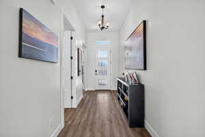 Entryway featuring wood finished floors and suspended lighting