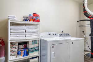 Laundry room featuring separate washer and dryer and wood finished floors