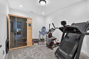 Exercise area featuring a sauna, light colored carpet, and recessed lighting