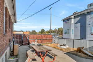 Fenced backyard with outdoor dining area, a patio, and a gate