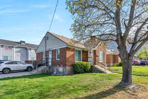 View of front of house with brick siding and a front lawn