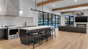 Kitchen featuring light countertops, a kitchen breakfast bar, stainless steel electric range, a center island, and decorative backsplash