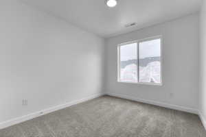 Spare room with light carpet and baseboards