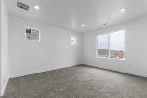 Unfurnished room featuring dark colored carpet and recessed lighting