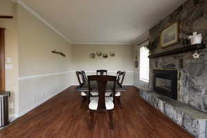 Dining space featuring a fireplace and dark wood-type flooring