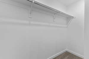Walk in closet featuring dark carpet