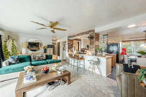 Living area featuring parquet flooring, a textured ceiling, a ceiling fan, and recessed lighting