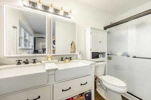 Bathroom featuring a shower stall and double vanity