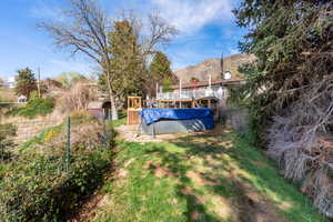 View of yard featuring a covered pool and a wooden deck