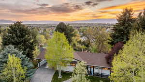 Aerial view of property and surrounding area featuring a tree filled landscape and a mountainous background