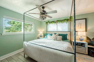 Owner's Bedroom with wood tiled floors, a ceiling fan, a textured ceiling, and a textured wall