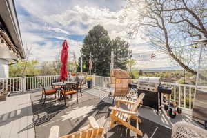 Wooden deck featuring grilling area and outdoor dining space