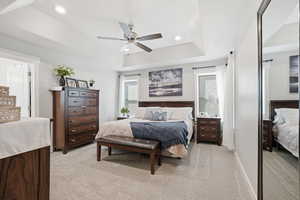 Bedroom featuring light carpet, recessed lighting, a raised ceiling, and ceiling fan