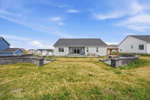 Rear view of house featuring a gazebo, a patio area, and a lawn
