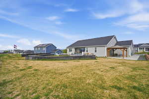 Rear view of property featuring a patio, a gazebo, a lawn, and a residential view