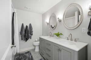 Full bathroom with double vanity and a shower with shower curtain