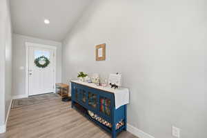 Foyer featuring light wood finished floors, vaulted ceiling, and recessed lighting