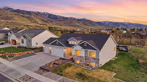 View of front of house featuring stone siding, driveway, a garage, and a mountain view