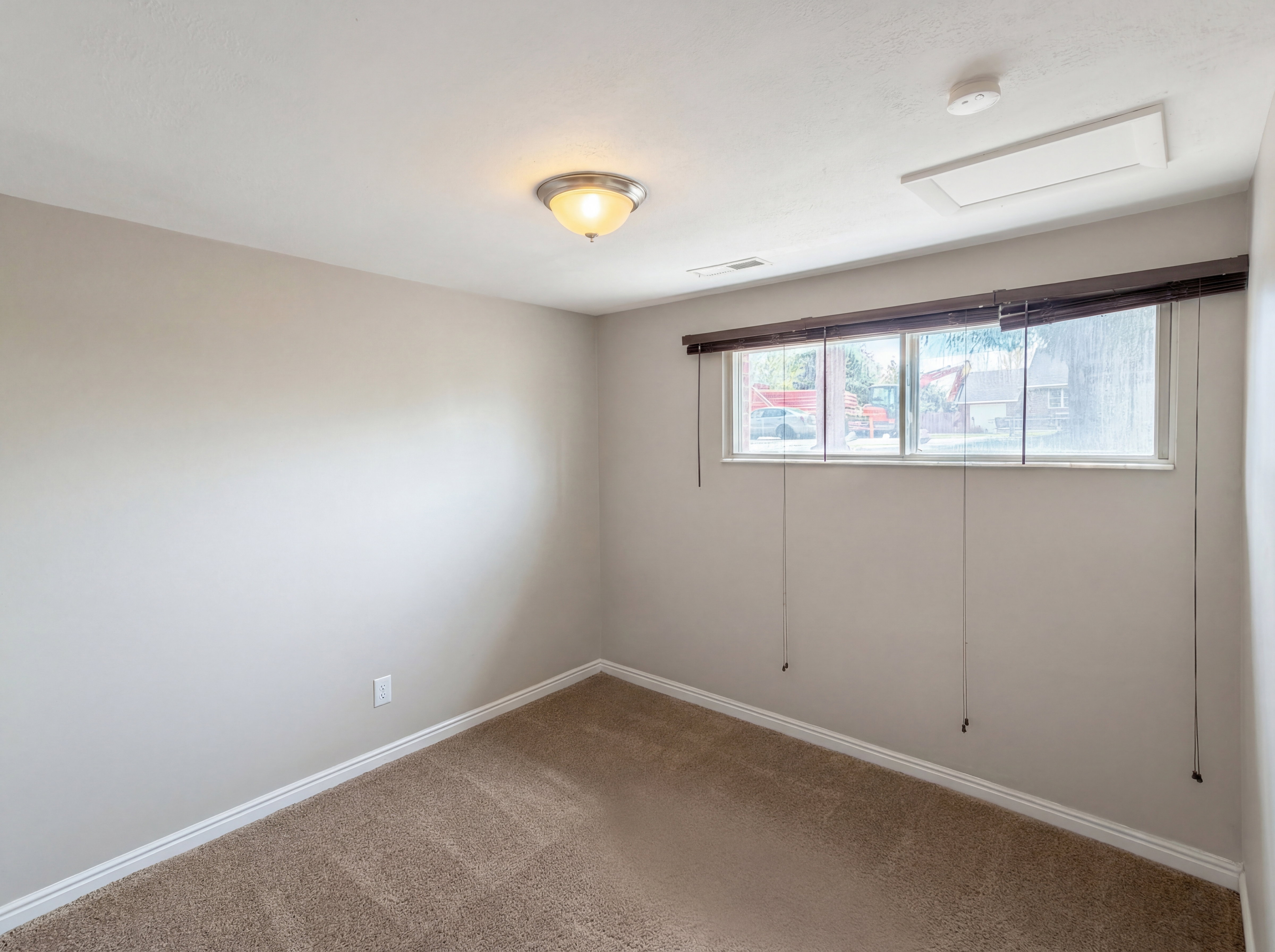 Carpeted spare room with attic access and a smoke detector