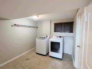 Laundry room with washer and clothes dryer and baseboards
