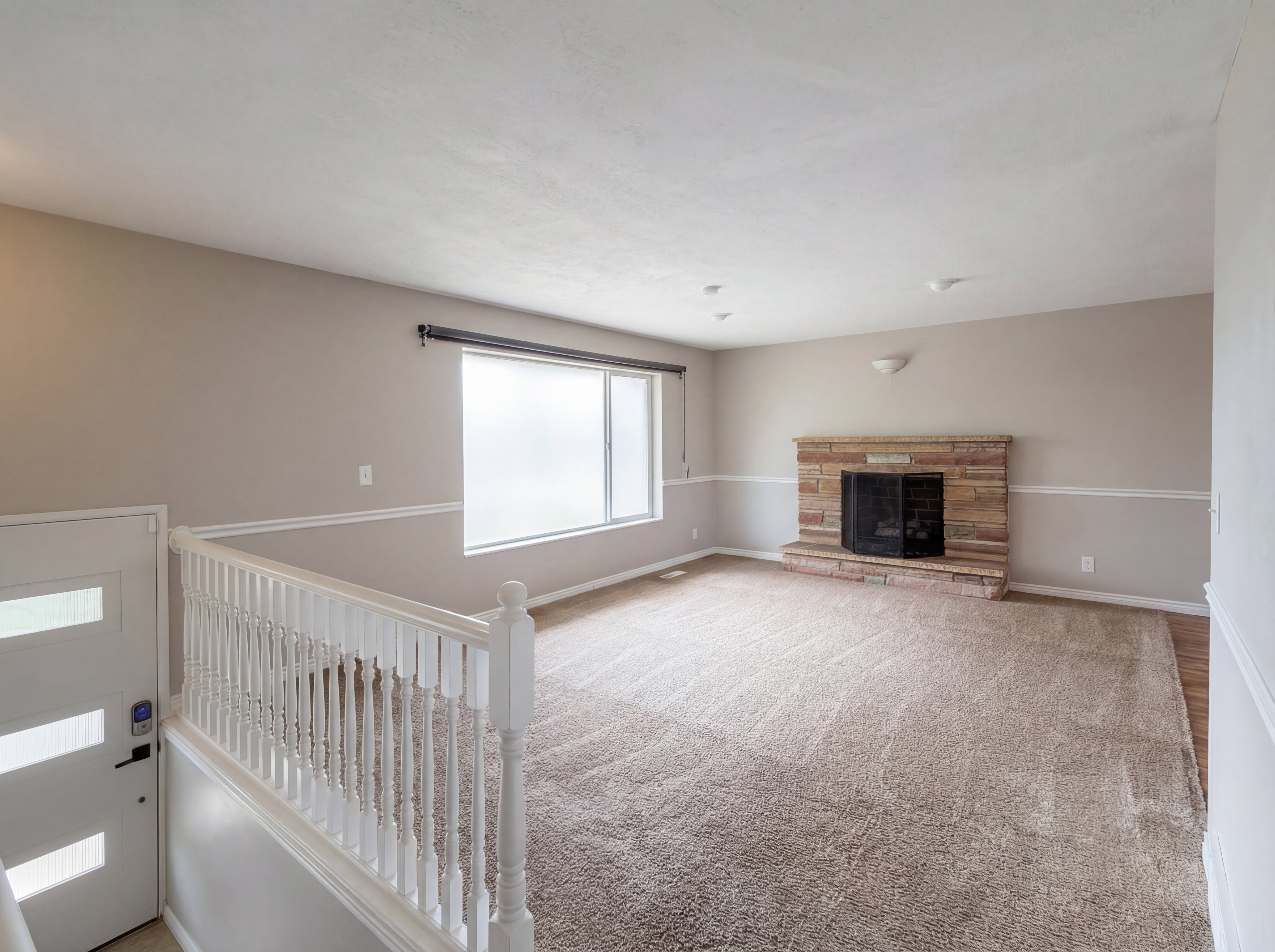 Unfurnished living room featuring light colored carpet and a stone fireplace
