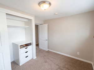 Unfurnished bedroom with a closet and light carpet