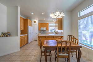 Dining room with a chandelier and light tile patterned floors