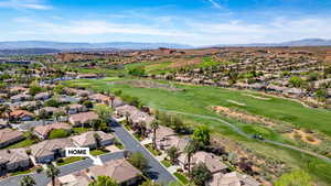 Aerial view of residential area with a golf course and a mountainous background