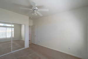 Unfurnished bedroom with a closet, ceiling fan, and carpet floors