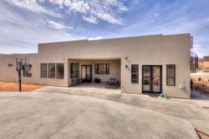 Back of house featuring a covered patio, open patio and spiral stairs to rooftop deck