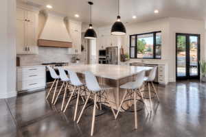 Kitchen with concrete floors, French doors, & large island