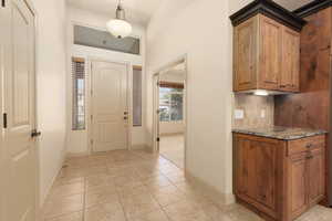 Foyer entrance with baseboards and light tile patterned floors
