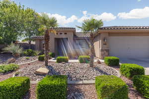 Mediterranean / spanish-style house with an attached garage, driveway, stucco siding, a tile roof, and stone siding