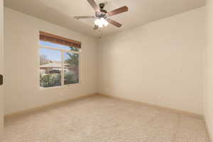 Unfurnished room featuring light carpet and a ceiling fan