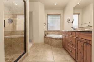 Full bathroom featuring double vanity, a garden tub, a stall shower, recessed lighting, and light tile patterned floors