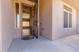 Entrance to property with stucco siding and a patio area